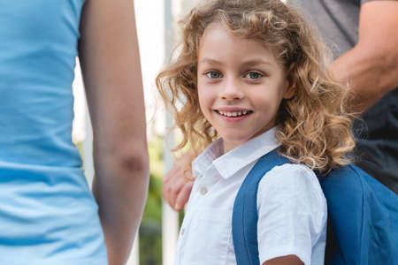 Smiling young girl walking to school with her parentsの写真素材