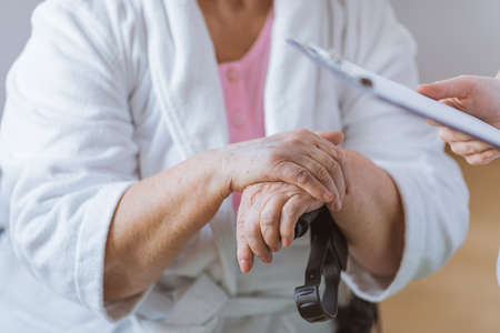 Close-up of older woman's hand holding a railwayの写真素材