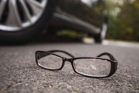 Broken glasses near the car on the streetの写真素材