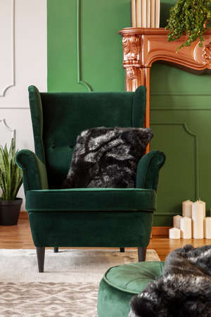 Wing back chair with pillow in contemporary living room interior with grey and green wallの写真素材