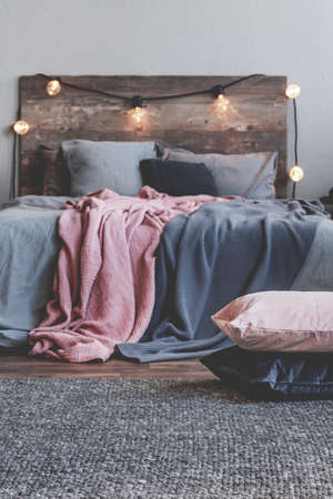 Vertical view of pile of pillows on the carpet of rustic bedroom interiorの写真素材