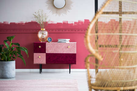 Stylish wicker peacock chair in trendy living room interior