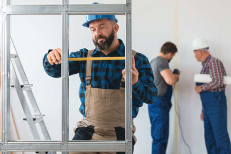 Three builders from construction crew renovating the houseの写真素材