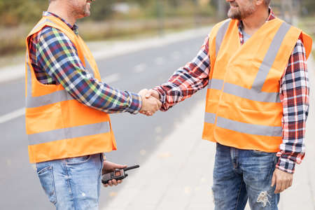 Two builder shaking hand on the road construction fieldの写真素材