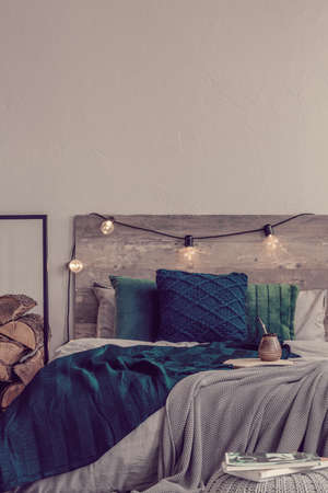 Vertical view of rustic bedroom design and copy space on empty grey wall