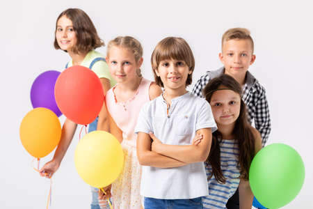 Group of smiling children with balloons on a white backgroundの写真素材