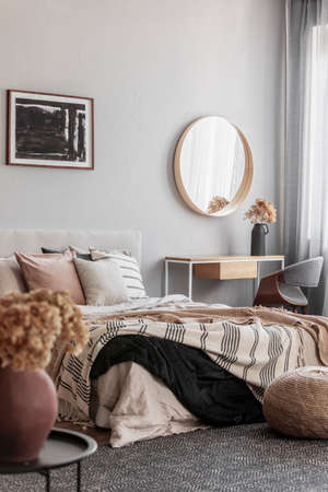 Cozy pillows on comfortable big king size bed in bright bedroom interior in elegant apartmentの写真素材