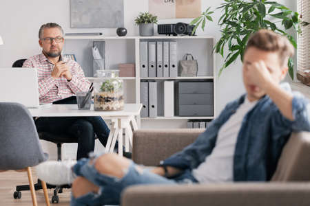 Young man with depression sitting in a psychotherapy session