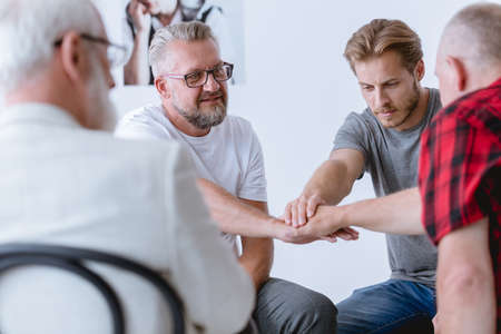 Group of man in different age sticking together on psychotherapy