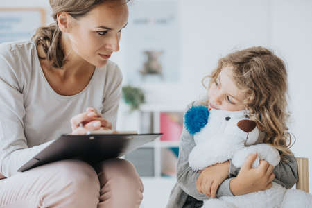 Young teacher giving private lessons to little girl after schoolの写真素材