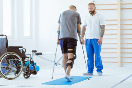 Injured patient learns to walk on crutches in medical officeの写真素材