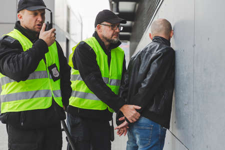 Close up of policemen speaking on the walkie-talkie during interventionの写真素材
