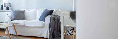 Copy space on empty white wall in beautiful studio apartment with small living roomの写真素材