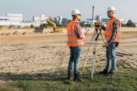 Two road construction workers using measuring device on the fieldの写真素材