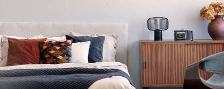 Trendy bedroom with comfortable king size bed in modern flat, real photo