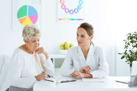 Professional dietician talking about healthy diet during nutrition consultation with a patientの写真素材