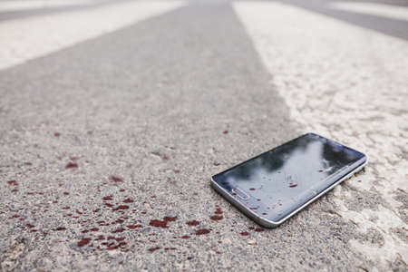 Bloody phone on the street after the accidentの写真素材