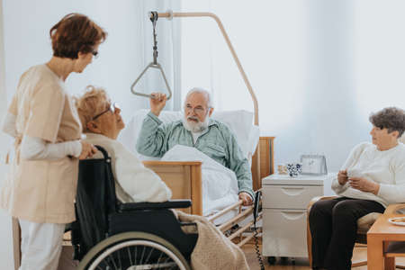 Senior people visiting injured friend in the hospitalの写真素材
