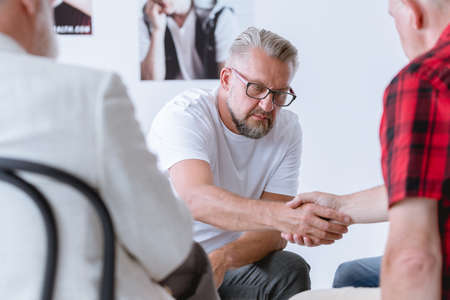 Men shaking hands during psychotherapy for people with addictions