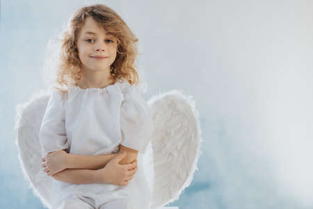Little smiling angel with wings on a white backgroundの写真素材