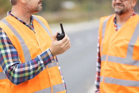 Road construction workers talking to walkie-talkieの写真素材