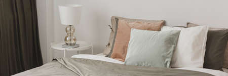 Close-up of pastel pillows on a bed in a romantic bedroom interiorの写真素材
