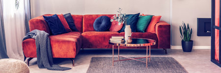 Flowers in stylish vase on small coffee table in bright living room interiorの写真素材