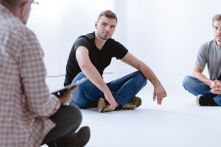 Psychologist talking with his male patients during sessionの写真素材