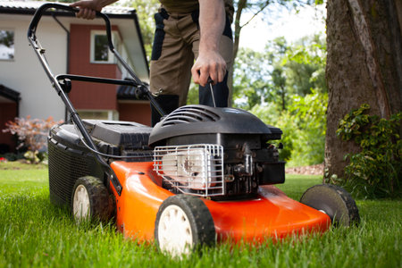Closeup of professional gardener turning on the lawn mowerの写真素材