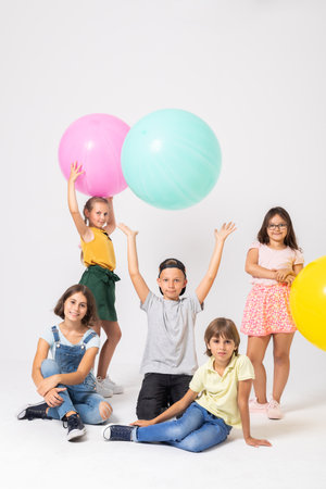 Happy children throwing the balloons in the airの写真素材