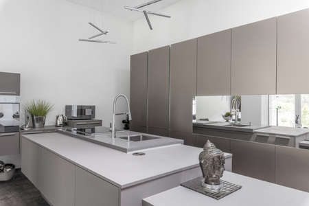 Gray modern kitchen with island and silver accessoriesの写真素材