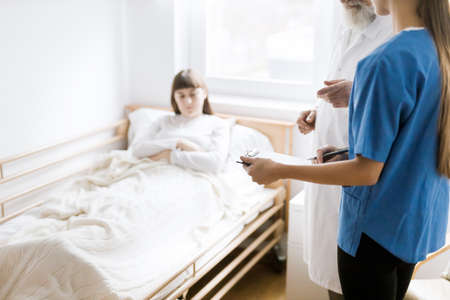 Profession doctors and helpful nurses with patients trying to find diagnoseの写真素材