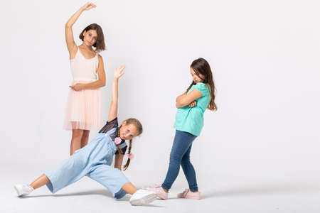 Group of cool girls fooling around in white room, making funny posesの写真素材