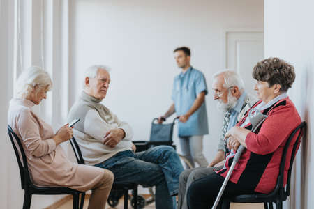 Group of senior people waiting in a line in a hospital hallwayの写真素材