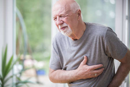 Senior gray man home alone having a heart attackの写真素材