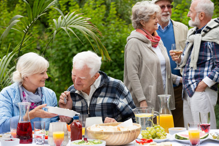 Group of happy senior people during garden partyの写真素材