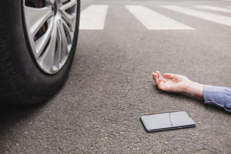 Unconscious pedestrian lying on the street hit by a carの写真素材