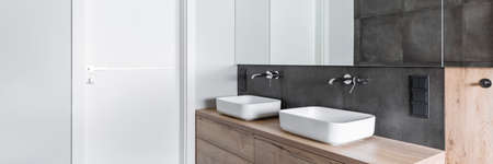 Double sinks in elegant white, concrete and wooden bathroom interiorの写真素材