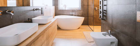 Stylish bathroom with wooden and concrete walls and white bathの写真素材