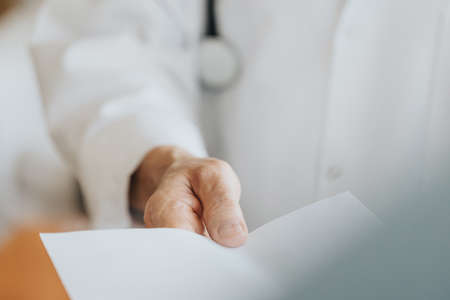 Close-up of senior doctor giving the prescribtion to the patientの写真素材