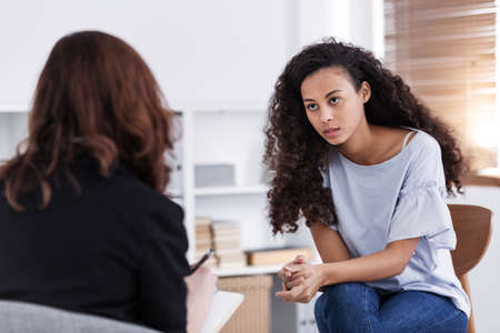 Professional counselor and woman suffering from depression during therapyの写真素材