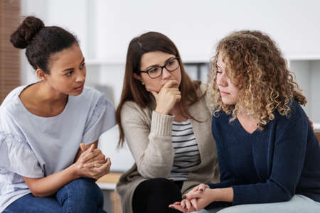 Sad woman crying during psychotherapy at professional clinicの写真素材