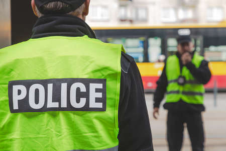 Word police written on reflective vests of police officers