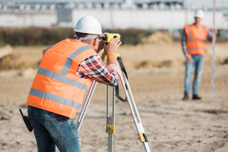 Geodesist measuring surfce area before starting the worksの写真素材
