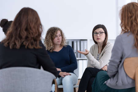Women with problems sitting together during counselingの写真素材