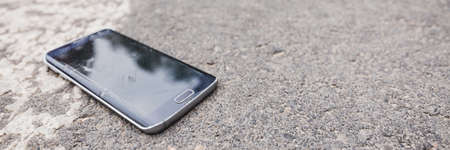 Close-up of broken phone on the road after the accidentの写真素材