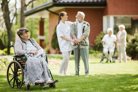 Elder disabled woman on the wheelchair reading a bookの写真素材