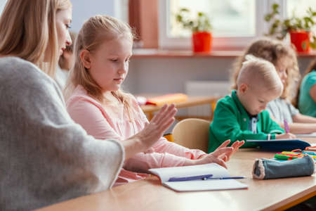 Happy children sit together at the table during the first physics lesson in the new school year