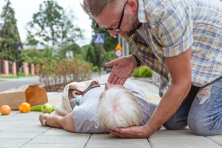 First aid to an accident victim lying on the streetの写真素材