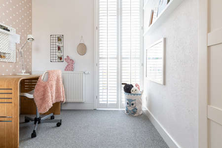 Cute kid's room with toys, modern desk and chair with pink blazerの写真素材